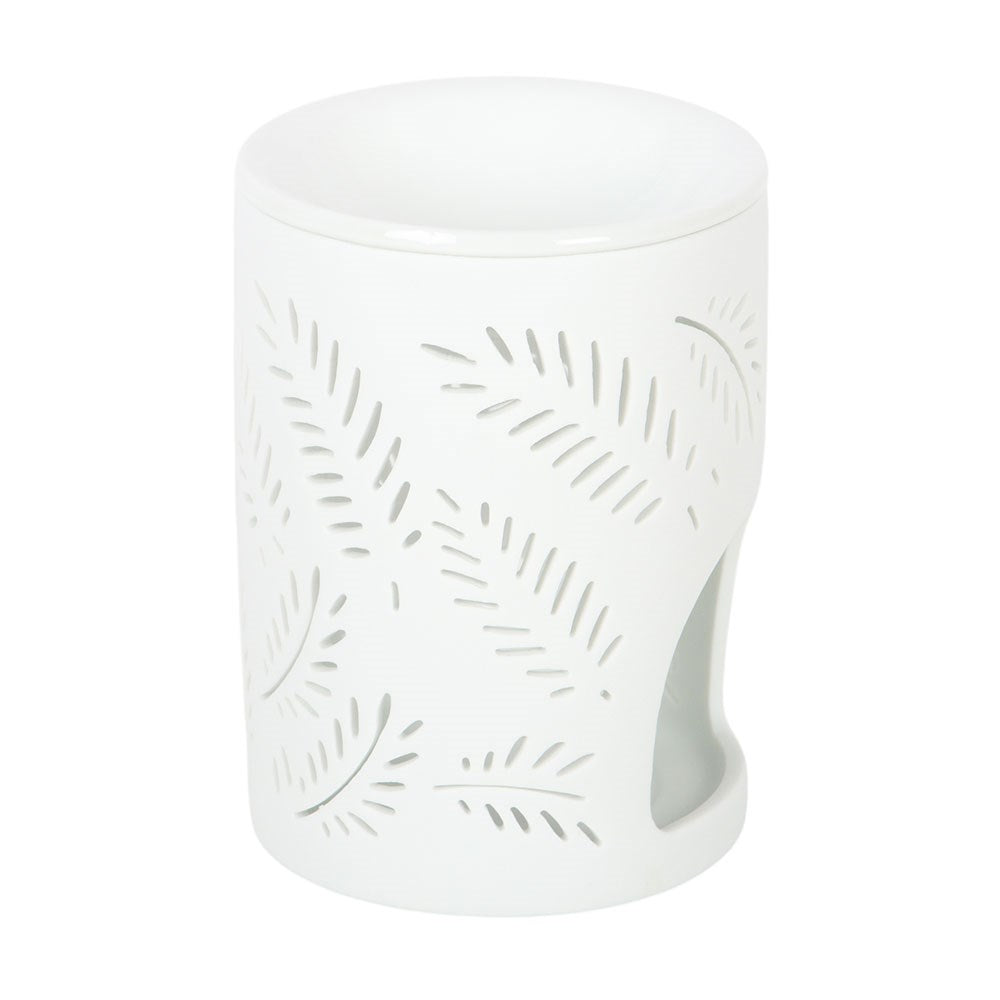 Witte oliebrander met varenbladeren en theelichtje